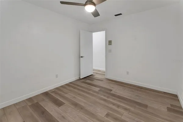 a view of an empty room with wooden floor