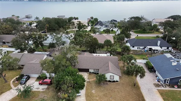 an aerial view of a house with a yard and lake view
