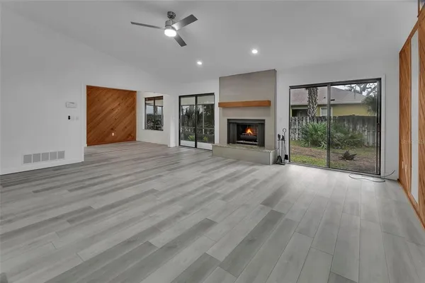 a view of empty room with wooden floor and fireplace