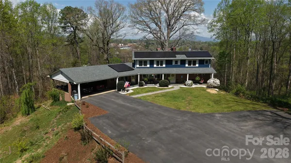 a view of a house with pool and next to a yard