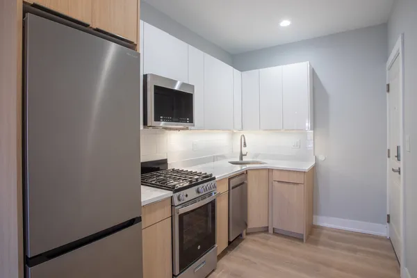 a kitchen with granite countertop a sink stove and refrigerator