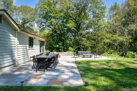 a view of a house with backyard and sitting area
