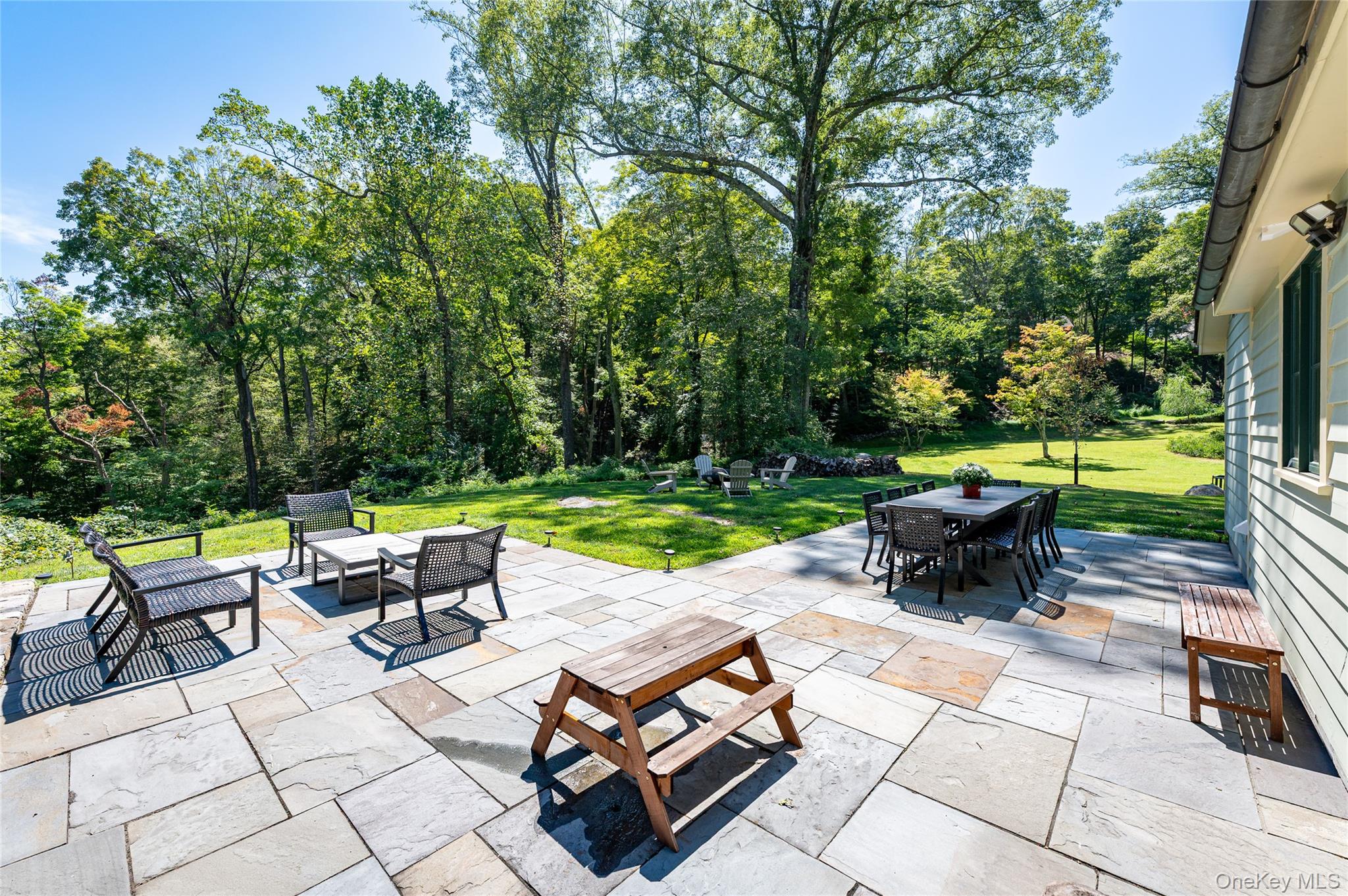 1355 Journeys End Road Croton-on-Hudson, NY 10520 - Photo 39 of 47 a view of a patio with table and chairs potted plants and a palm tree