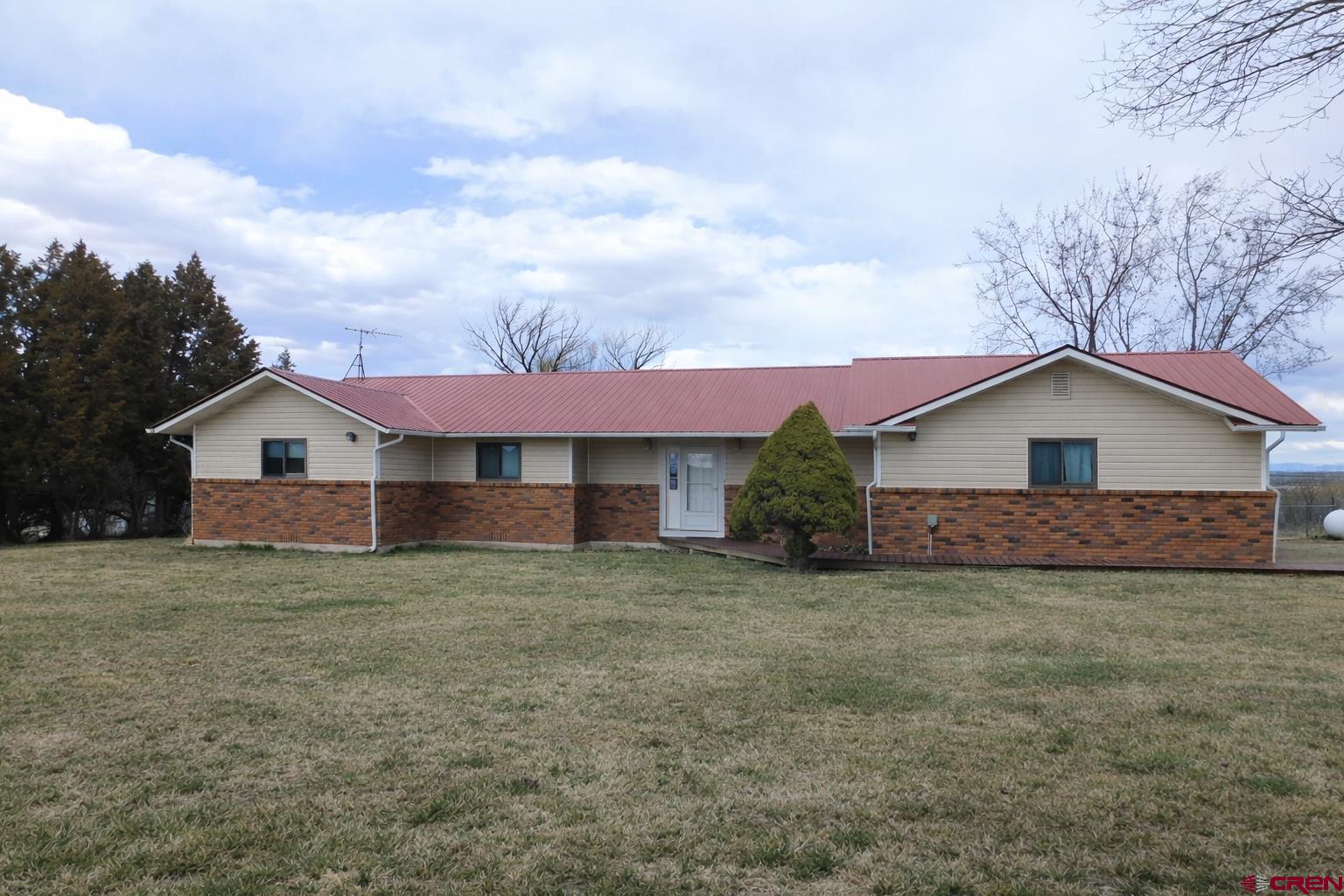 19825 Rd P Cortez, CO 81321 - Photo 1 of 38 a front view of a house with a yard and garage
