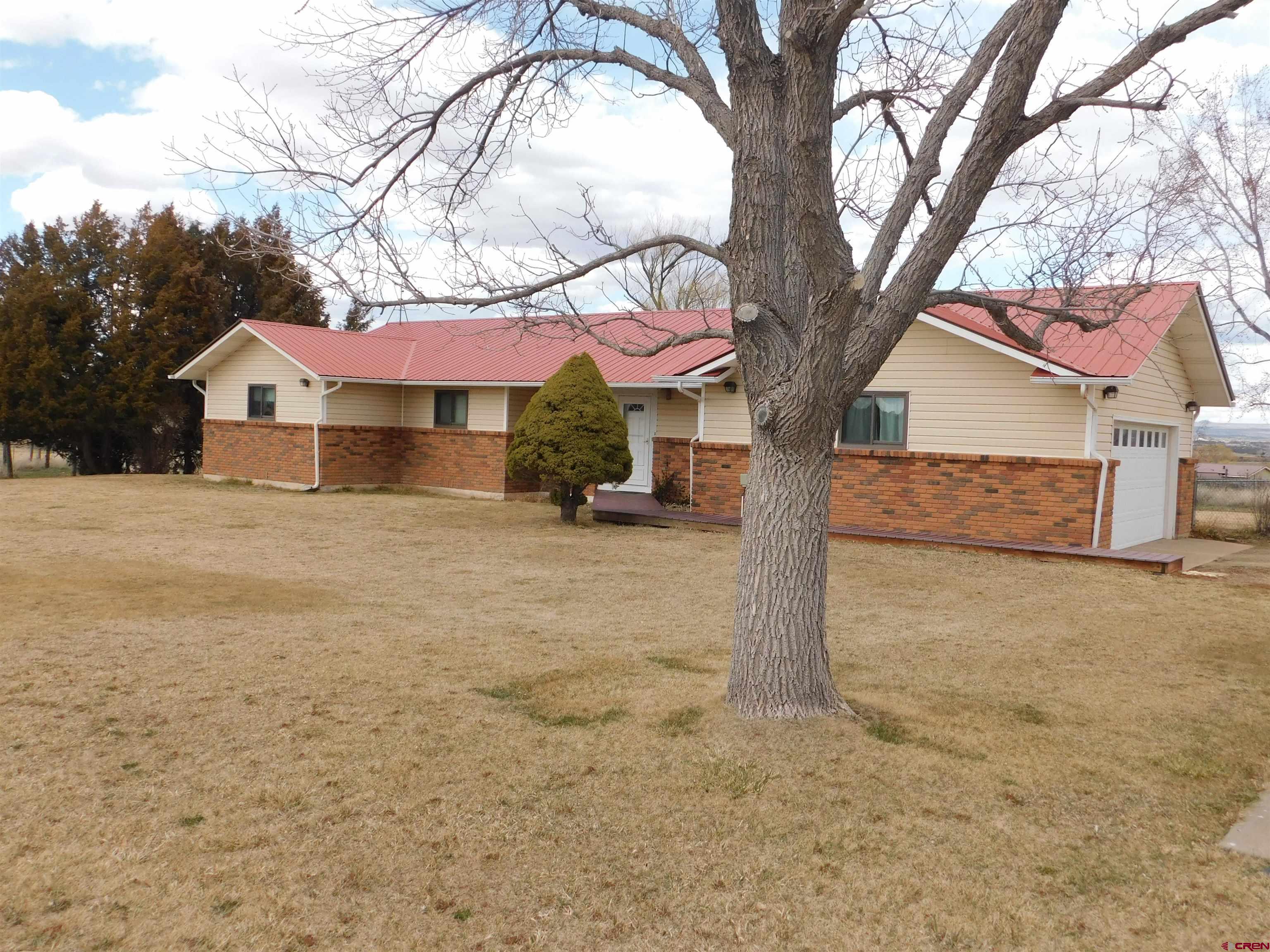 19825 Rd P Cortez, CO 81321 - Photo 31 of 38 a front view of a house with a yard and garage