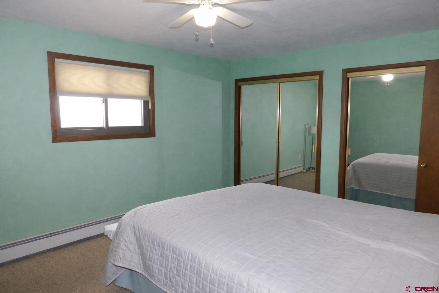 19825 Rd P Cortez, CO 81321 - Photo 9 of 38 a bedroom with a bed and a chandelier