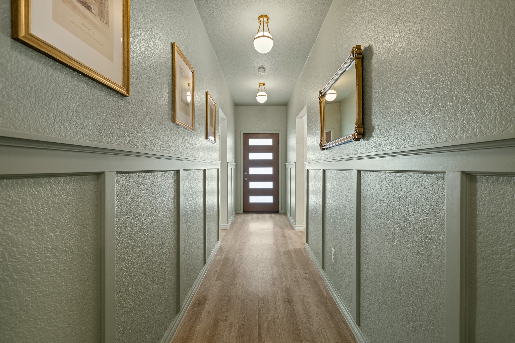 129 Maybelline Road Jarrell, TX 76537 - Photo 12 of 28 An inviting hallway showcases elegant wainscoting and smooth wood flooring leading to the main living areas.