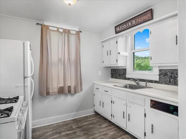 a kitchen with a sink cabinets stainless steel appliances and a window