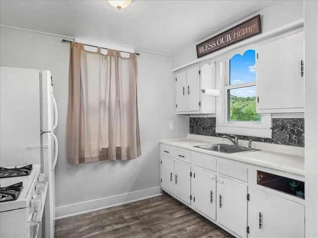 a kitchen with a sink cabinets stainless steel appliances and a window