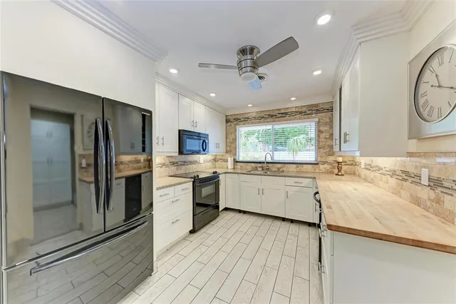 a kitchen with stainless steel appliances kitchen island granite countertop a stove top oven a sink dishwasher a dining table and chairs with wooden floor