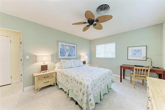 a bedroom with a large bed chandelier and a window