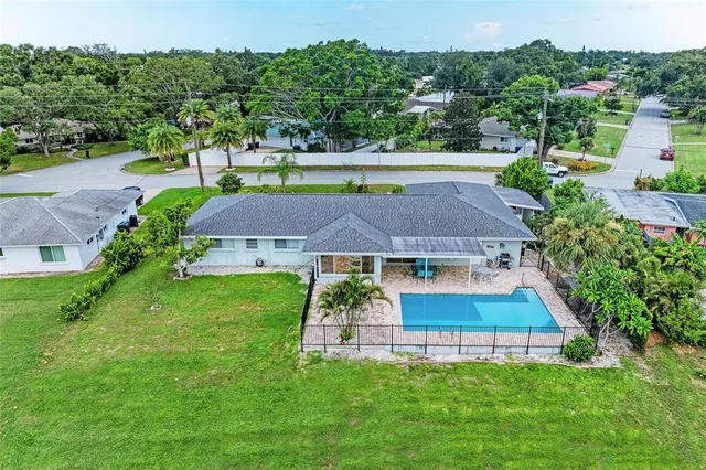 an aerial view of residential houses with outdoor space and trees