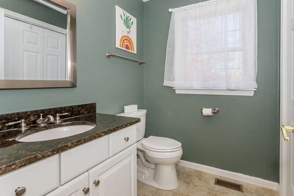 226 Daniels Street Franklin, MA 02038 - Photo 17 of 24 a bathroom with a granite countertop toilet sink and mirror