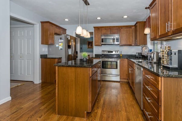 226 Daniels Street Franklin, MA 02038 - Photo 5 of 24 a kitchen with stainless steel appliances granite countertop wooden cabinets a refrigerator a stove a sink and a microwave