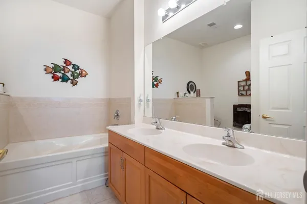 a bathroom with a tub sink and mirror