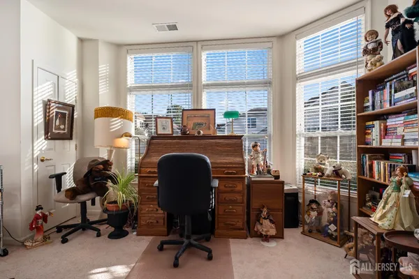 a view of a workspace with furniture and a window