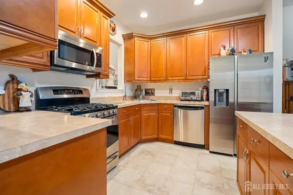 a kitchen with stainless steel appliances a stove sink refrigerator and cabinets