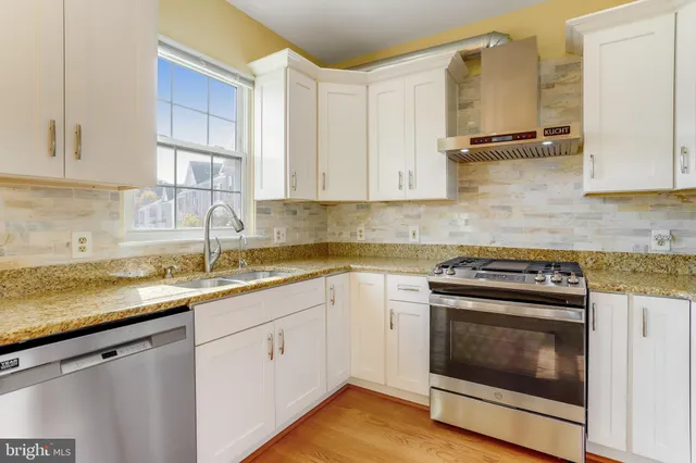 a kitchen with stainless steel appliances granite countertop a sink stove and cabinets