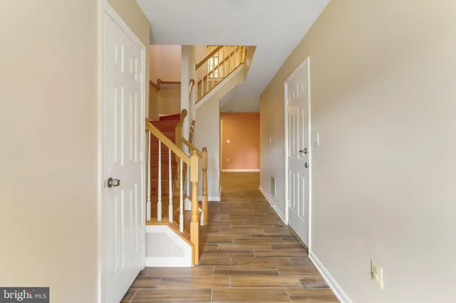 a view of a hallway with wooden floor and entryway