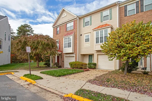 a front view of a house with garden and trees