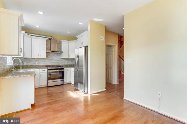 a kitchen with granite countertop a refrigerator and a stove top oven