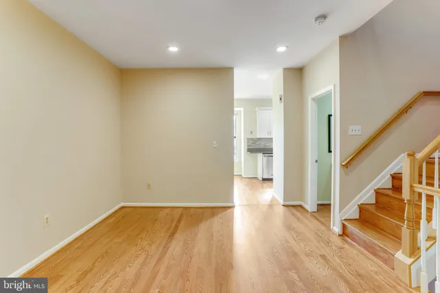 a view of empty room with wooden floor
