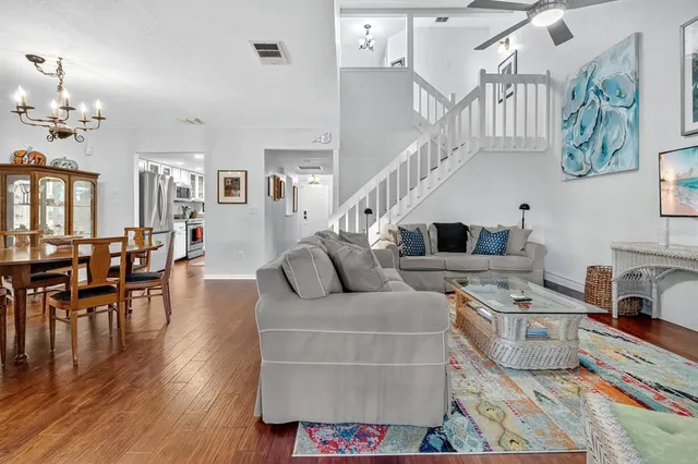 a living room with furniture wooden floor and dining table