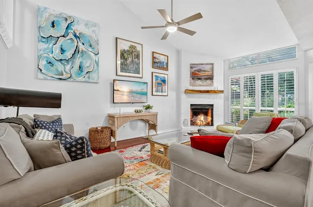 a living room with furniture a fireplace and a large window
