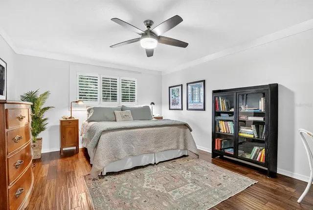a spacious bedroom with a large bed a chandelier and a book shelf