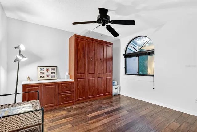 a view of a livingroom with wooden floor and a ceiling fan