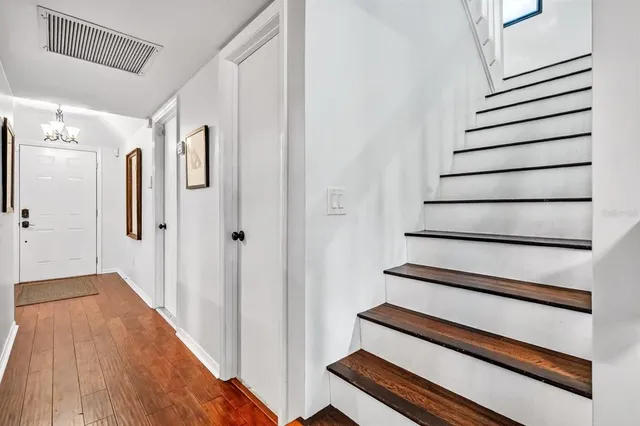a view of a hallway with wooden floor and entryway