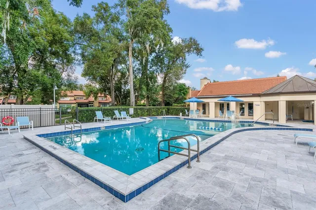 swimming pool view with a seating space and a garden view
