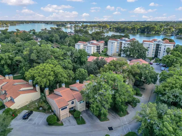 an aerial view of a house with a garden and lake view