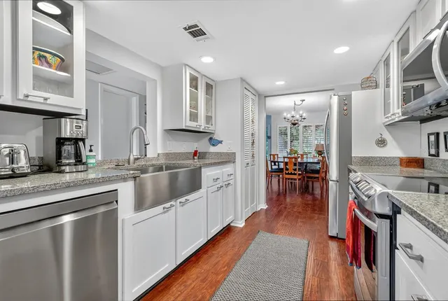 a kitchen with stainless steel appliances granite countertop lots of counter top space and wooden floor