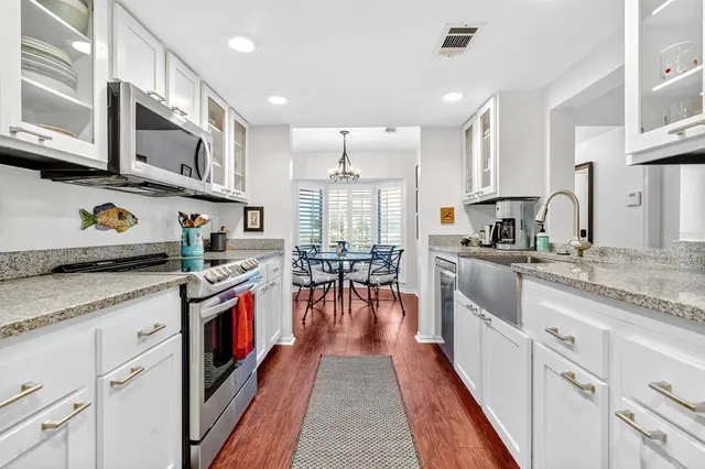a kitchen with stainless steel appliances granite countertop a stove and cabinets