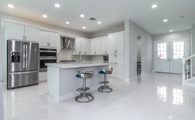 a kitchen with stainless steel appliances granite countertop a stove a sink and a refrigerator