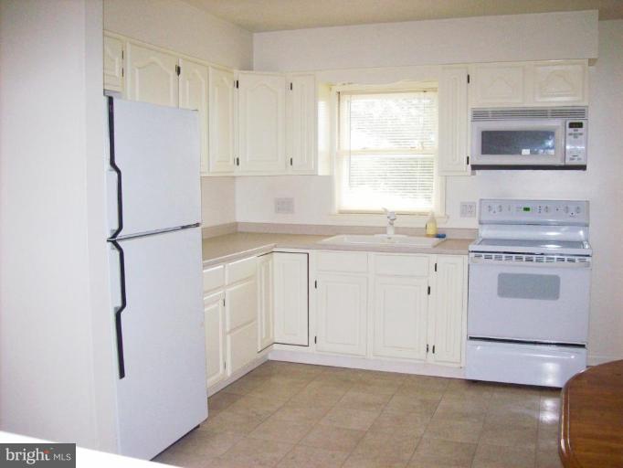114 Hoofprint Drive Bunker Hill, WV 25413 - Photo 12 of 13 a kitchen with white cabinets white appliances and sink