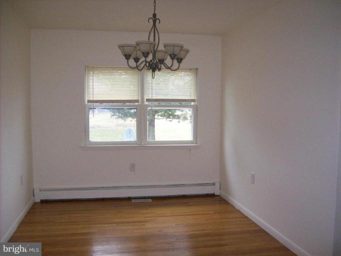 114 Hoofprint Drive Bunker Hill, WV 25413 - Photo 8 of 13 an empty room with wooden floor and windows