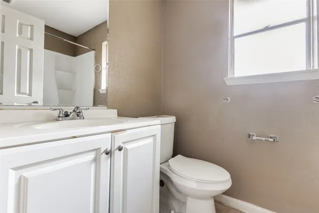 a bathroom with a sink mirror vanity and toilet