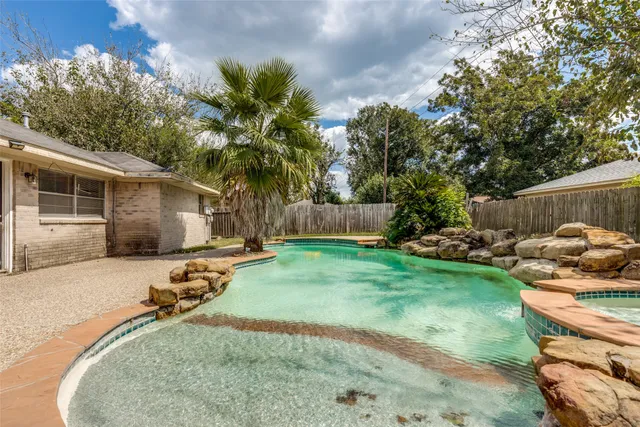 a view of a backyard with couches plants and large trees