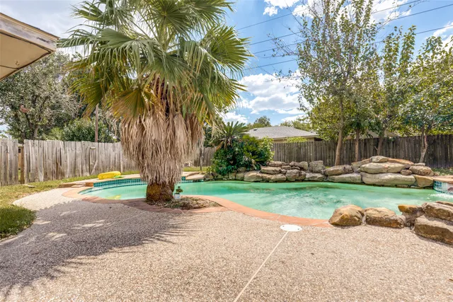 a front view of a house with garden and a car parked