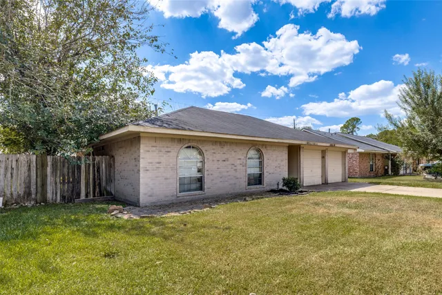 a view of a house with backyard and tree