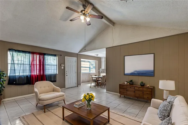 a living room with furniture a chandelier and a rug