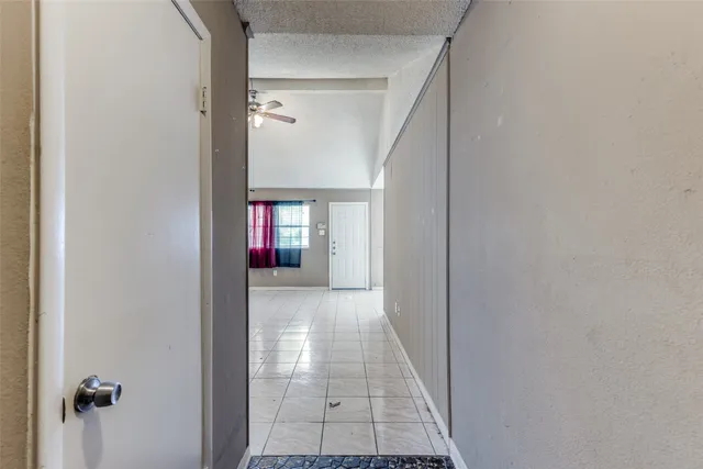 a view of a hallway with wooden floor and cabinet