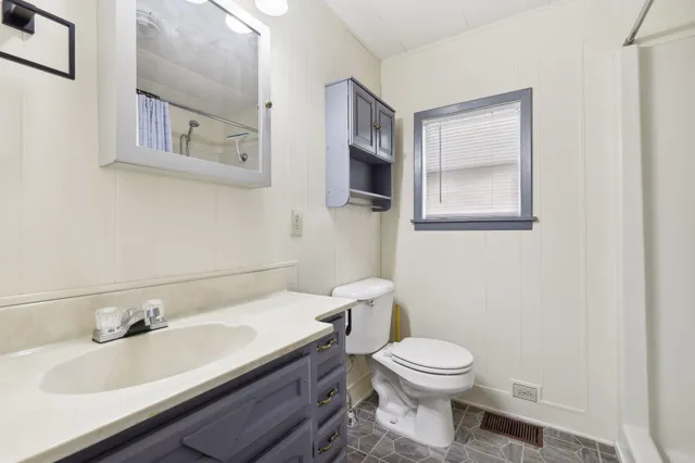 a bathroom with a toilet a sink and mirror