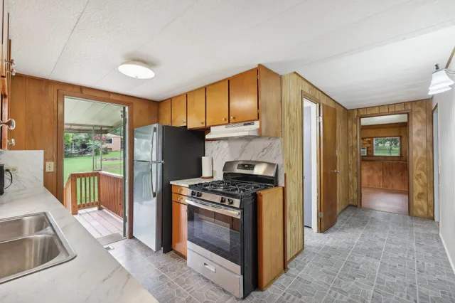 a kitchen that has a sink stainless steel appliances a counter space and a window