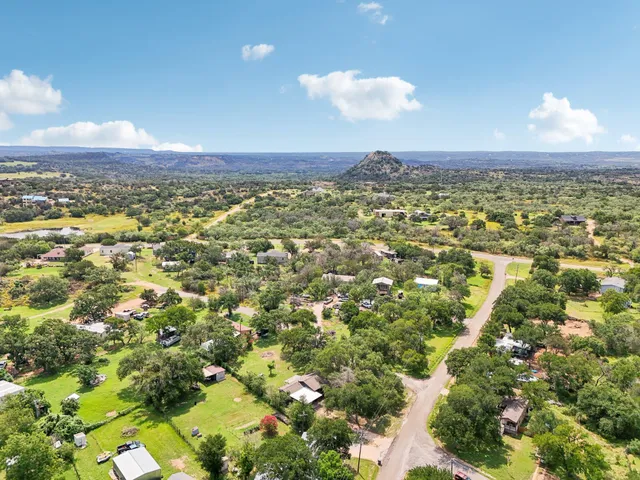 an aerial view of residential house with outdoor space and trees all around
