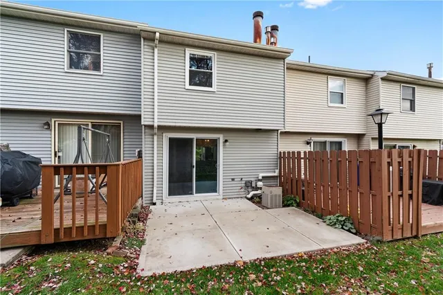 a view of a house with a backyard and wooden fence