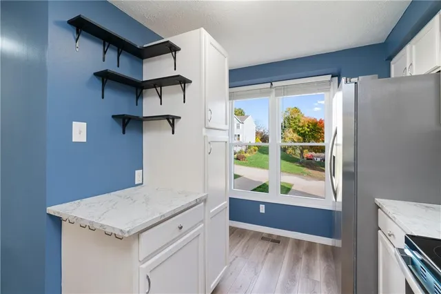 a kitchen with a wooden floor and a window