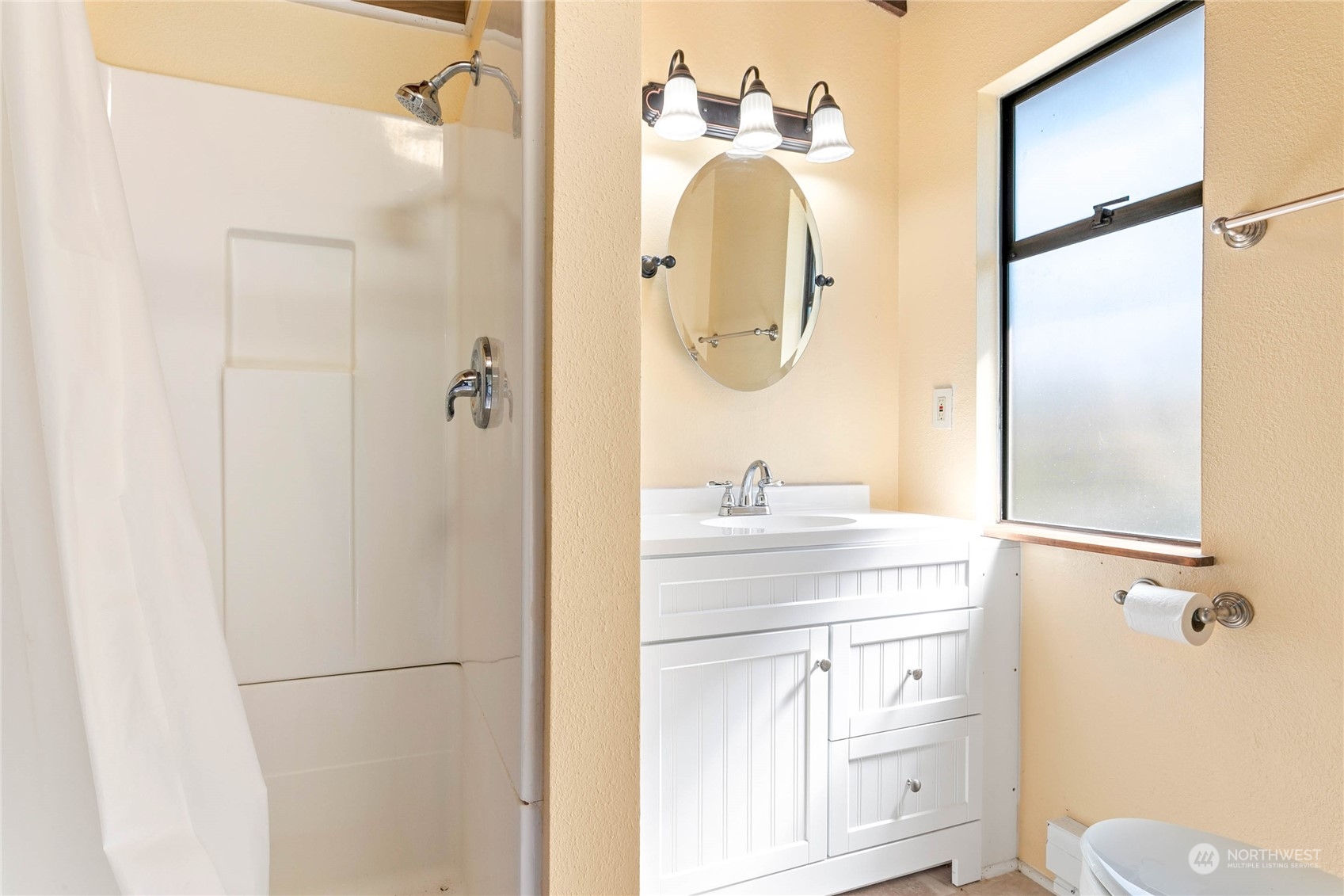 6402 Goodwin Road Everson, WA 98247 - Photo 21 of 39 a bathroom with a sink a mirror a toilet and shower